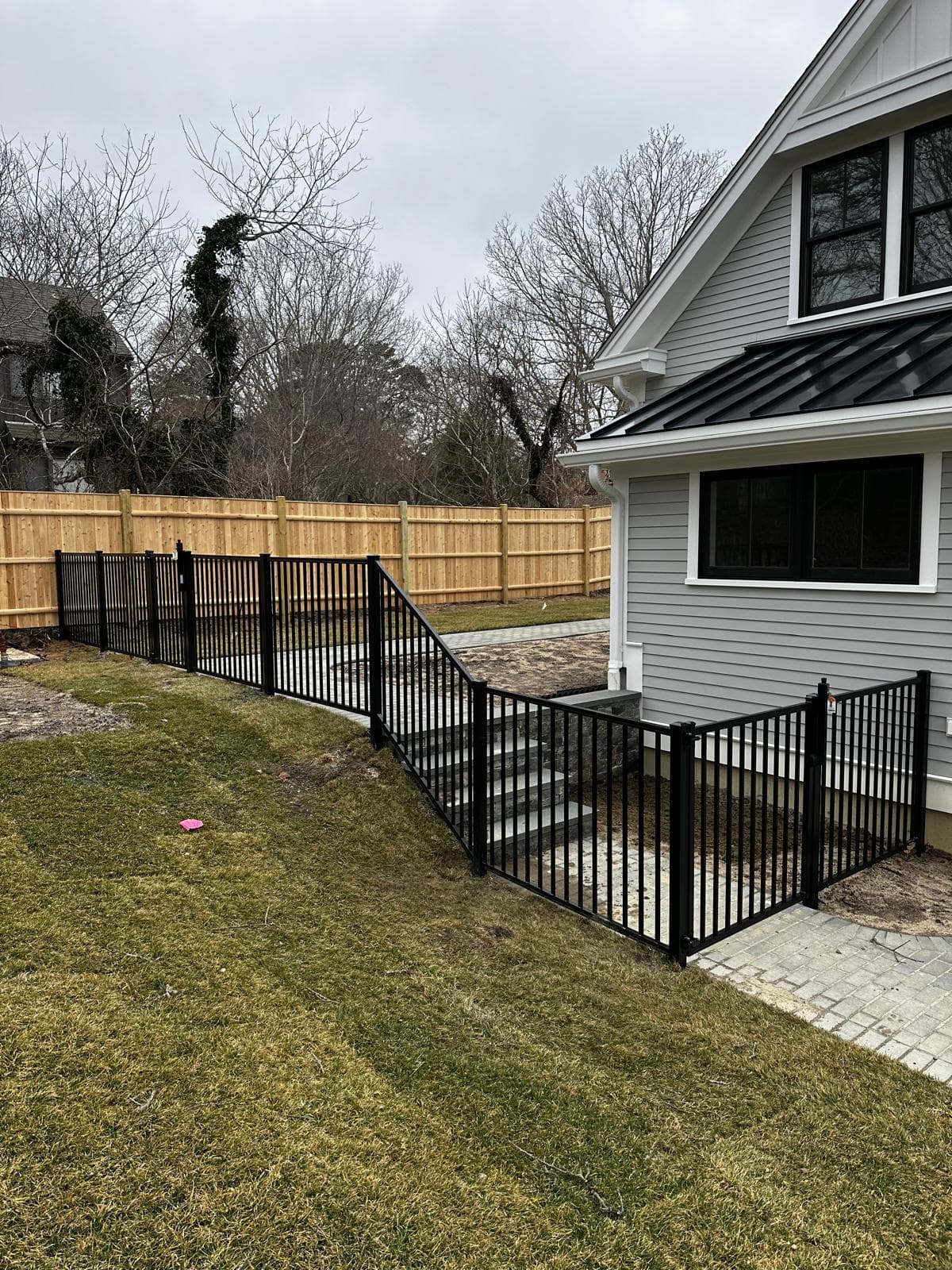 Black aluminum fence around backyard for pet containment — safe and secure