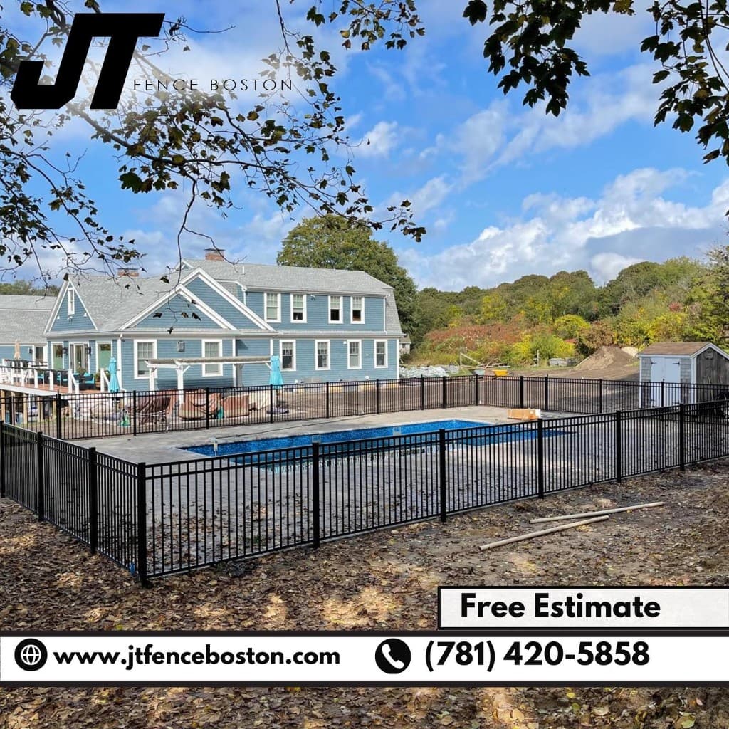Pool deck enclosed by black ornamental fence at a blue-sided Massachusetts home — professional pool barrier installation